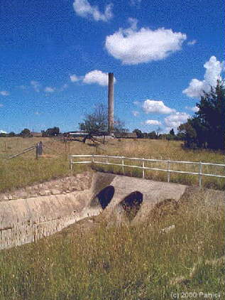 The entrance of the drain and a tall chimney behind it